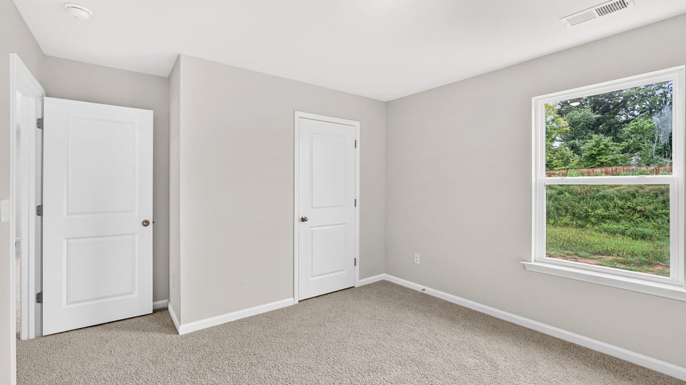 Bedroom with carpet and window.