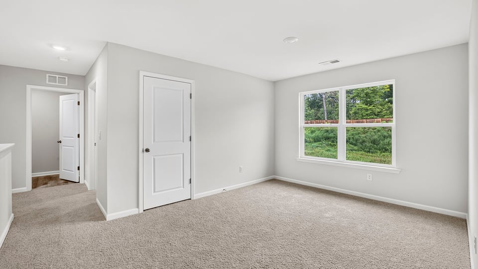Bedroom with carpet and window.