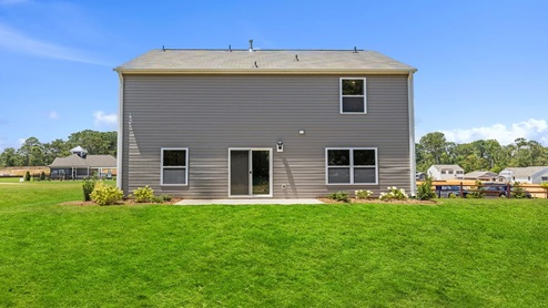 Back exterior of home with large backyard