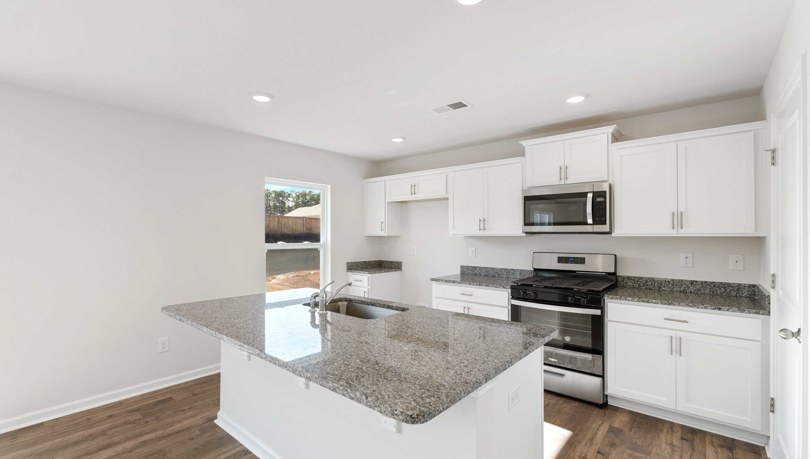 Kitchen and island with granite counter tops.