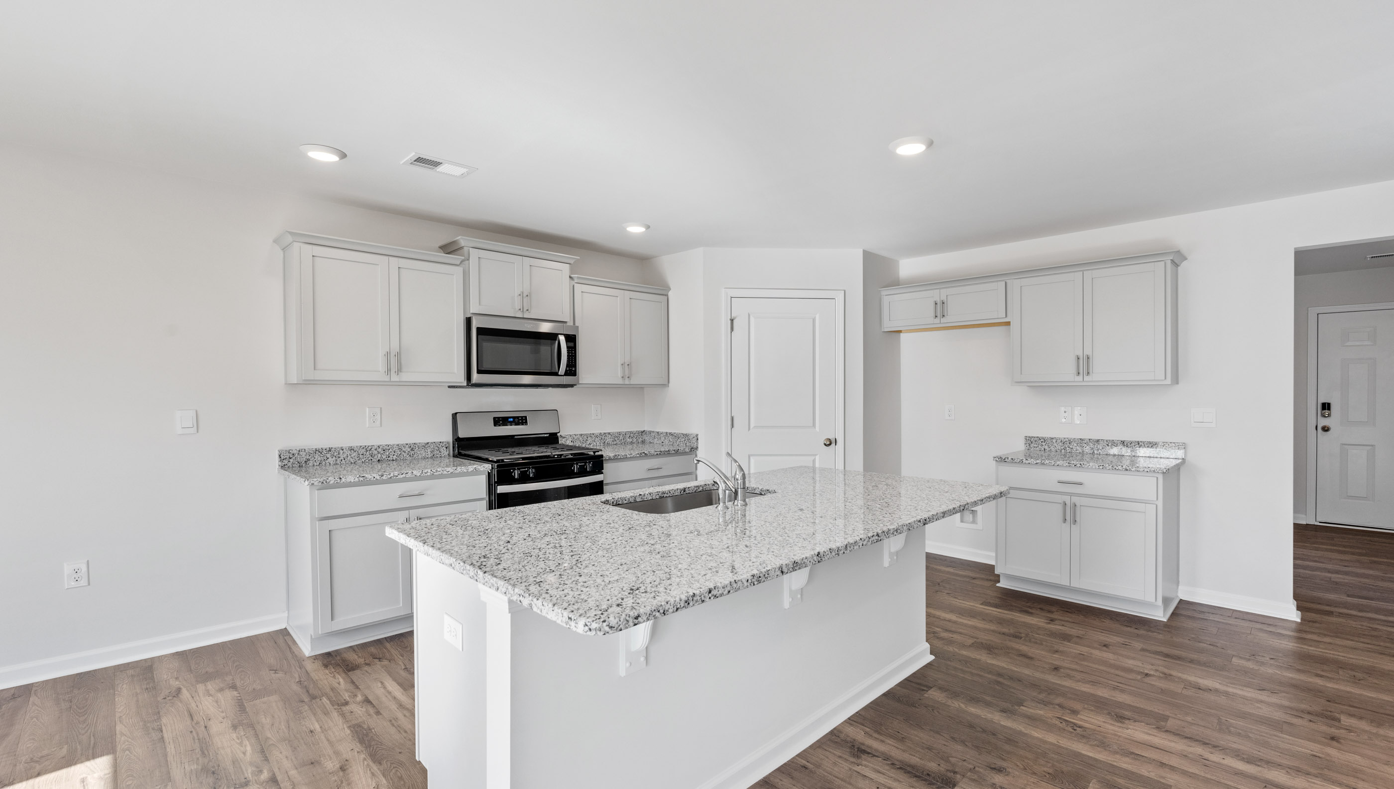 Kitchen and island with granite counter tops.
