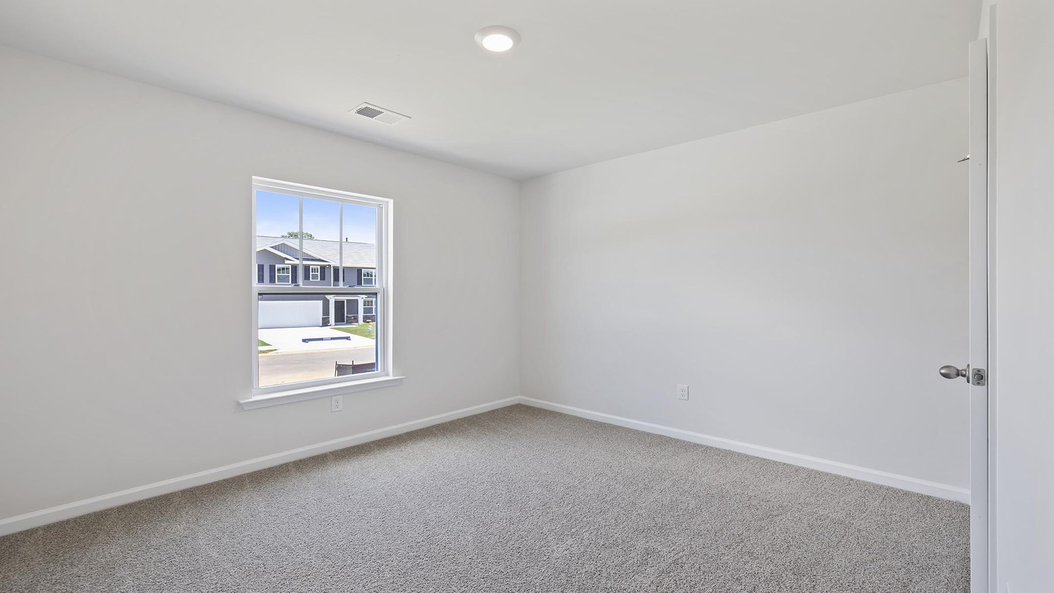 Bedroom with carpet and windows.