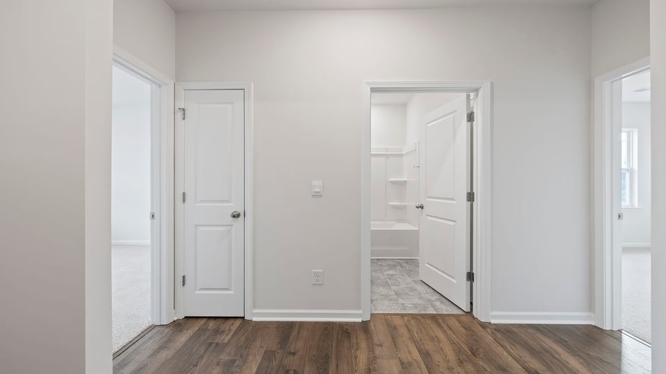 View of hallway and entrances to both bedrooms and hall bathroom.