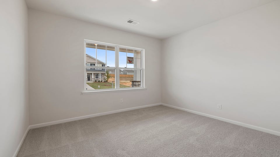 Bedroom with carpet and windows.