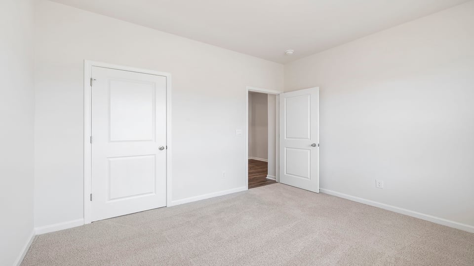 Bedroom with carpet and windows.