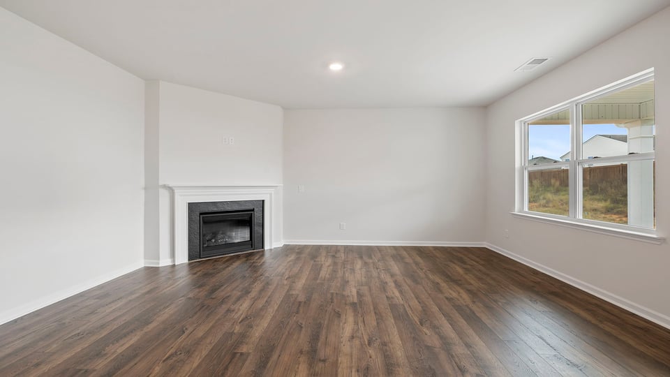Family room with gas log fireplace and large windows.