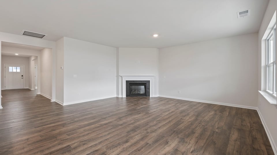 Family room with gas log fireplace and view of the hallway to the entrance.