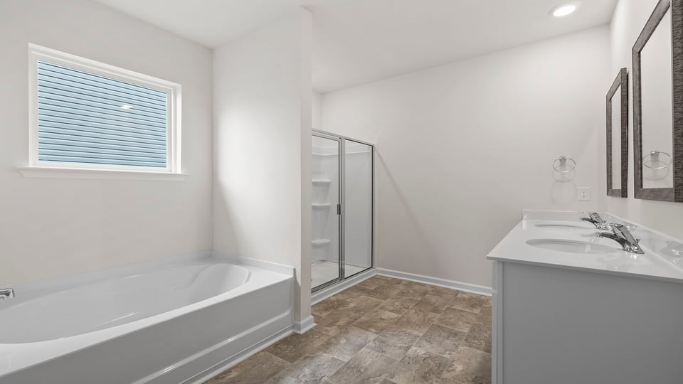 Primary bathroom with dual sink vanity, walk-in shower and garden tub.