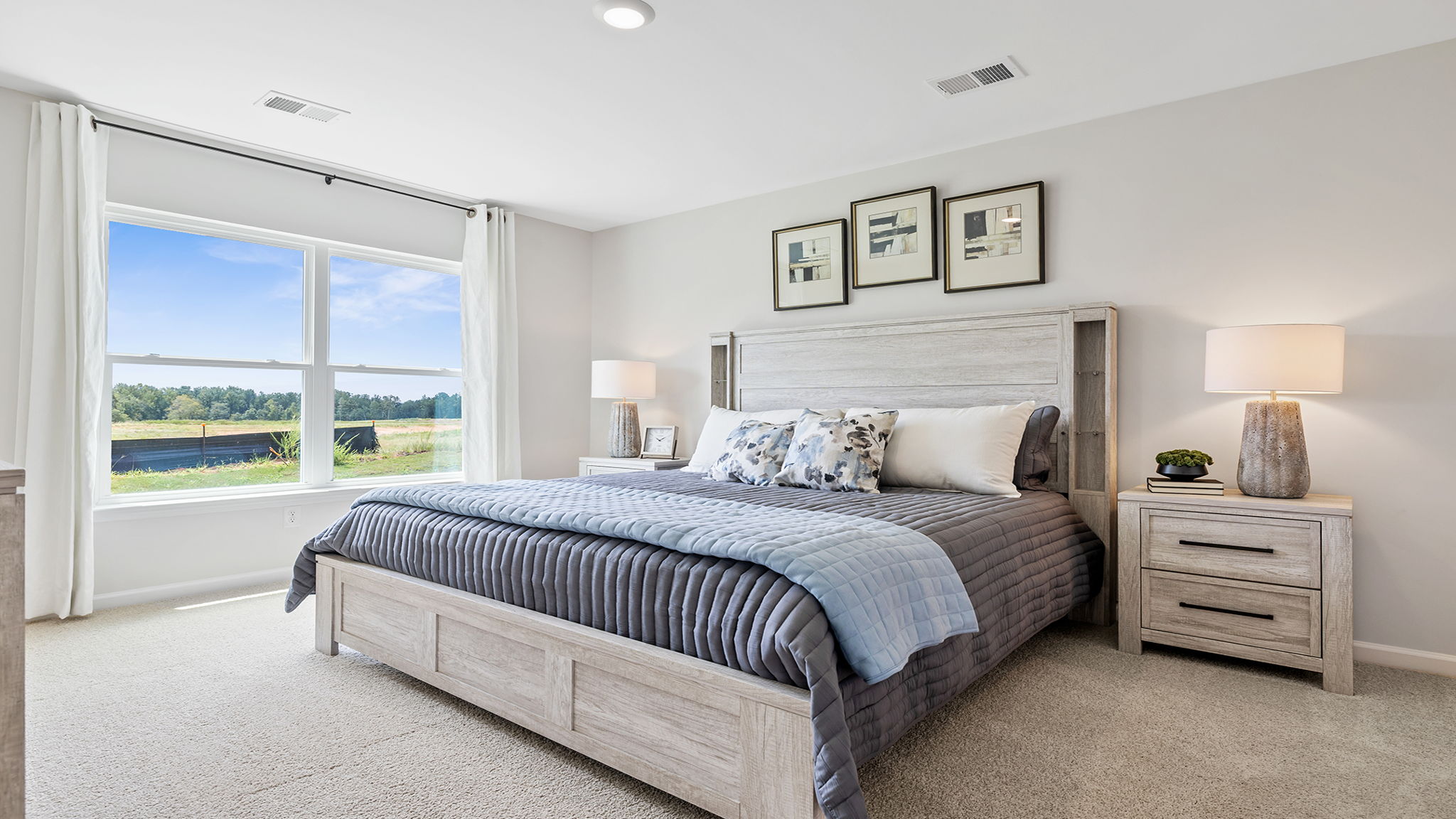 Primary bedroom with carpet and window.