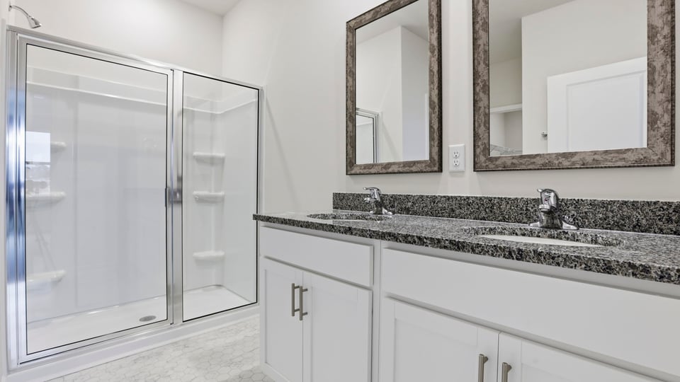 Primary bathroom with dual sink vanity and walk-in shower.