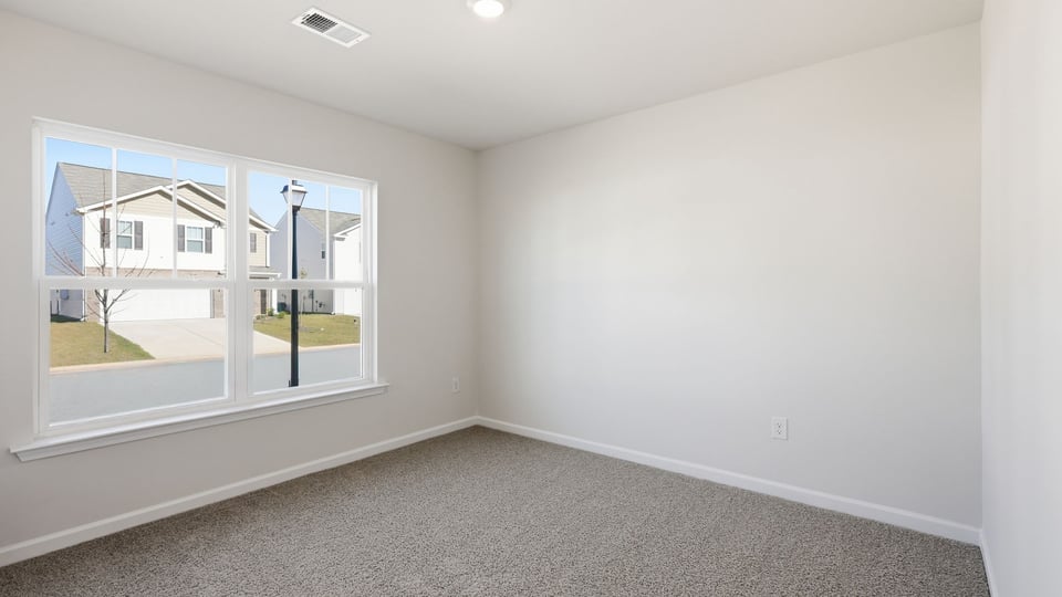 Bedroom with carpet and windows.