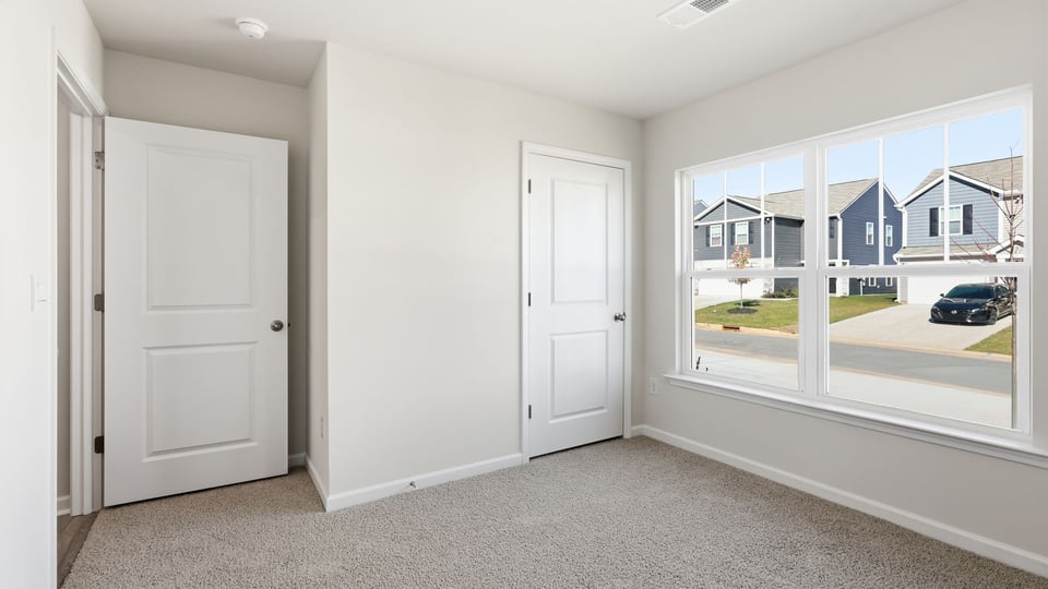 Bedroom with carpet and windows.