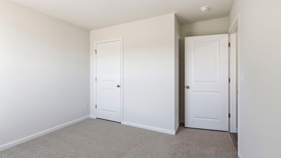 Bedroom with carpet and windows.