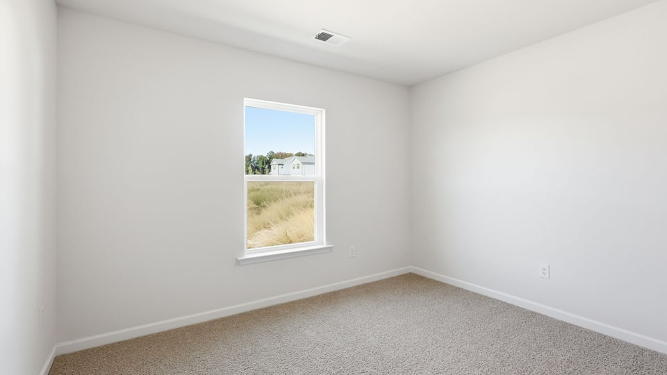 Bedroom with carpet and windows.