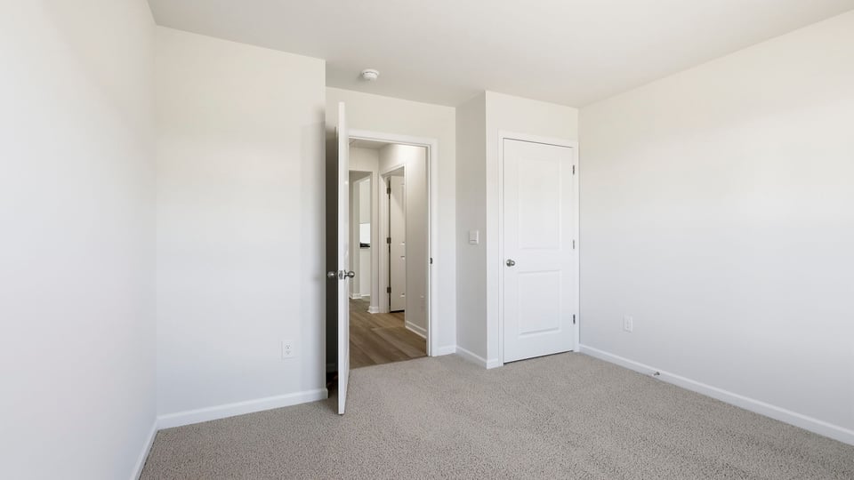 Bedroom with carpet and windows.
