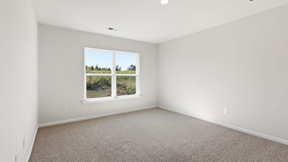 Bedroom with carpet and windows.