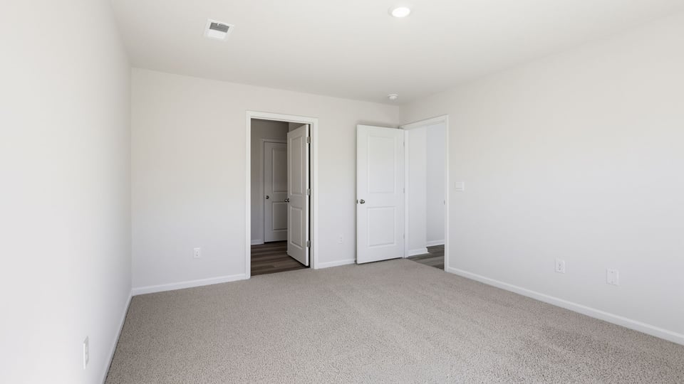 Bedroom with carpet and windows.