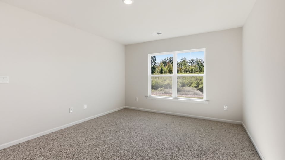 Bedroom with carpet and windows.