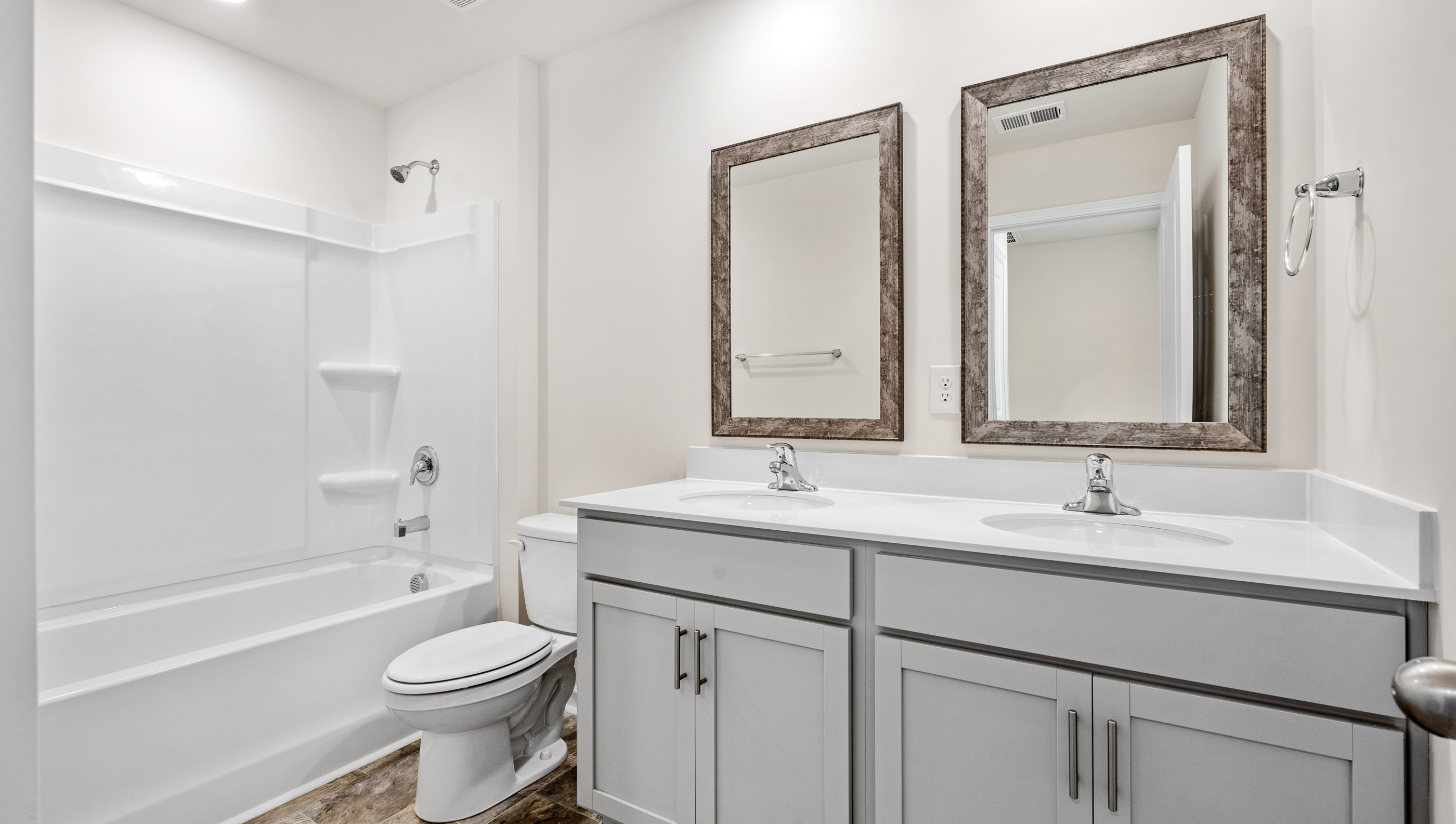 View of hall bath with dual sinks and combination tub and shower.