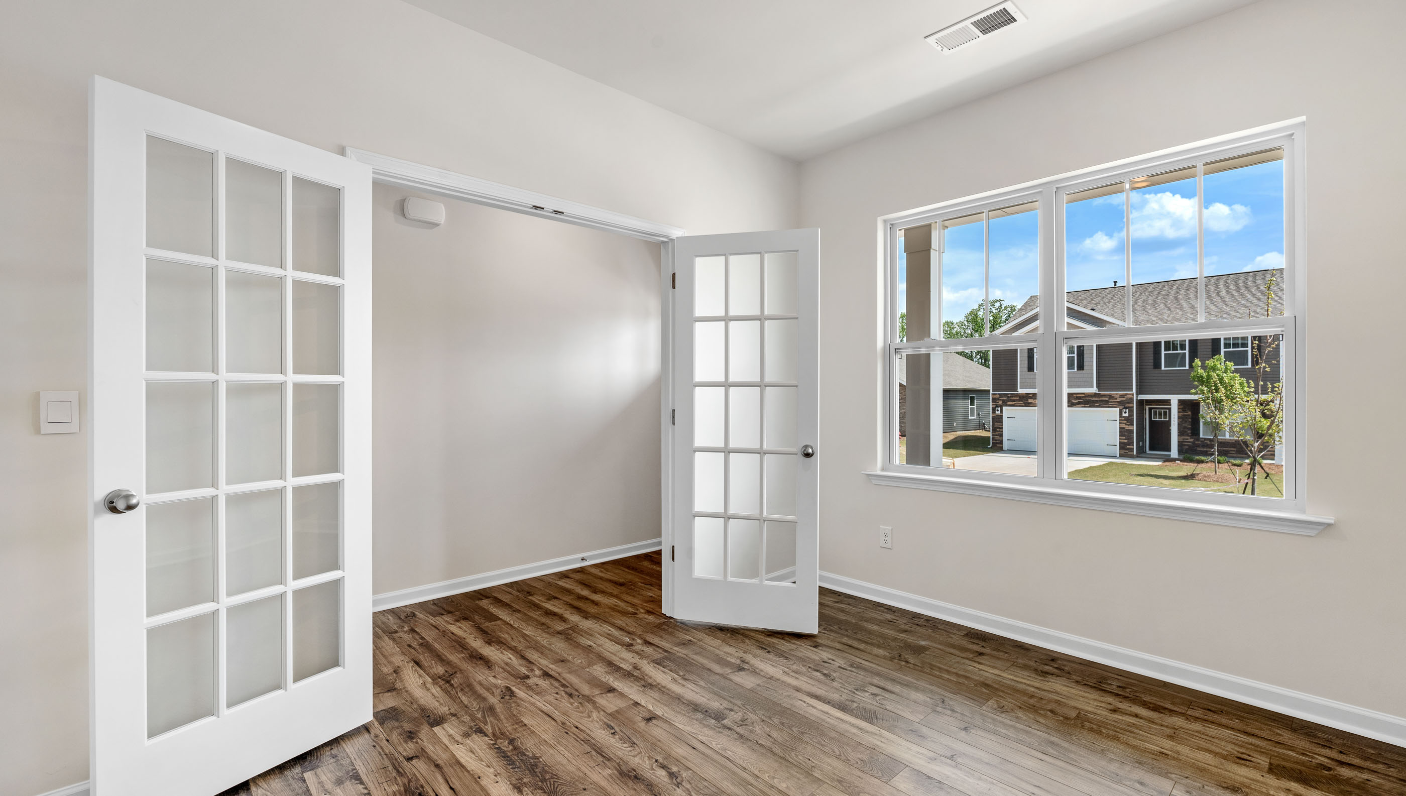 Study is located at the front of the home with large window and accented by French doors.