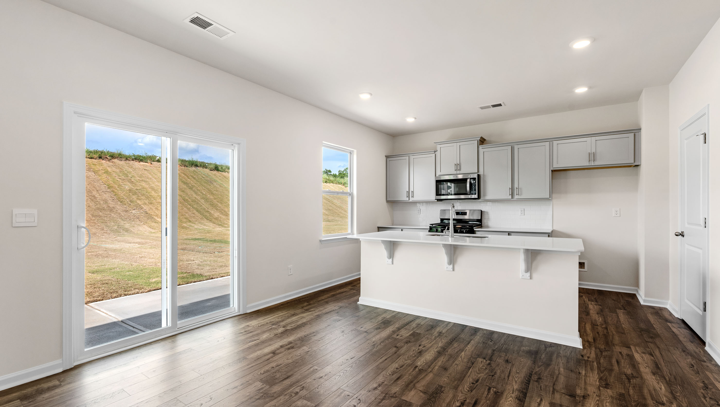View of patio door and kitchen with island.