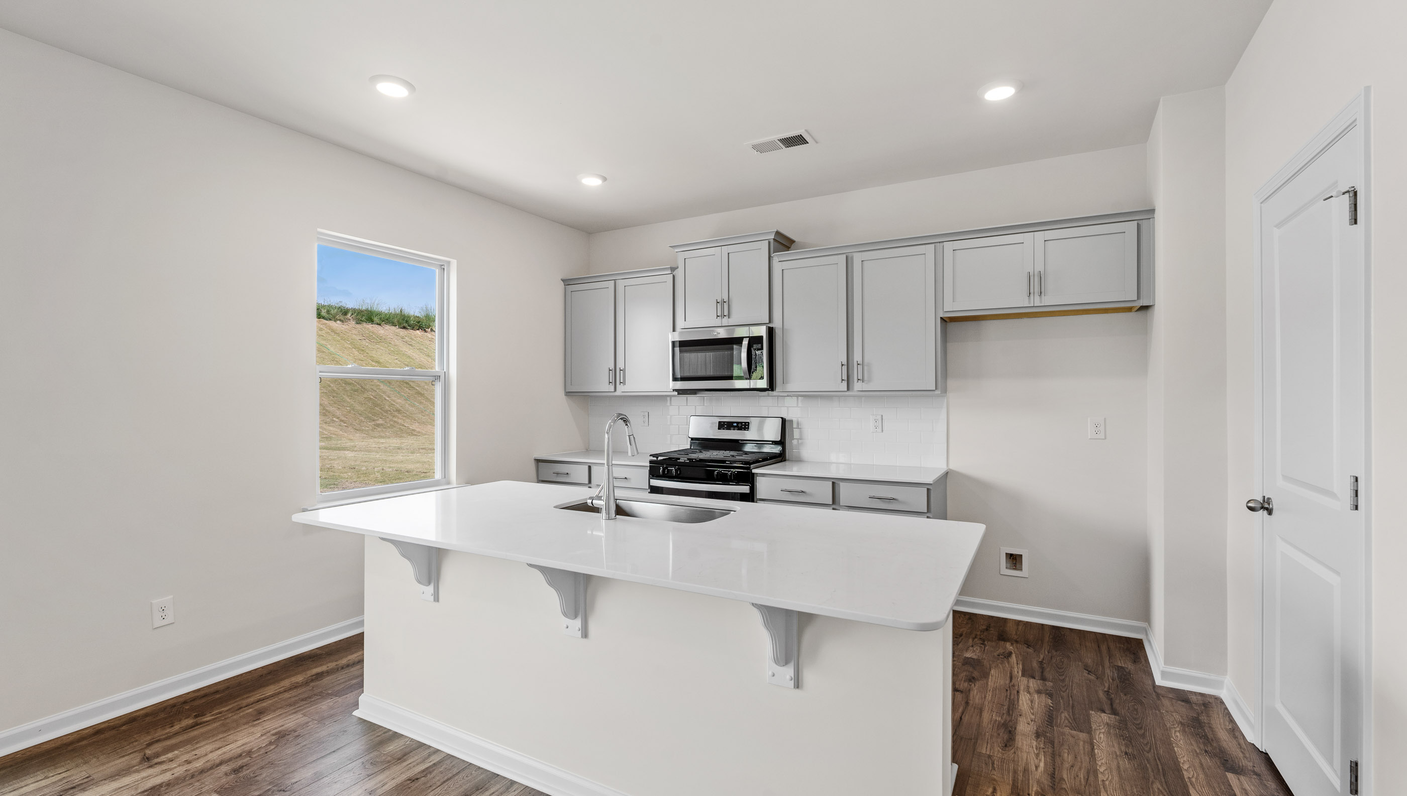Kitchen area with quartz countertops and stainless-steel appliances.
