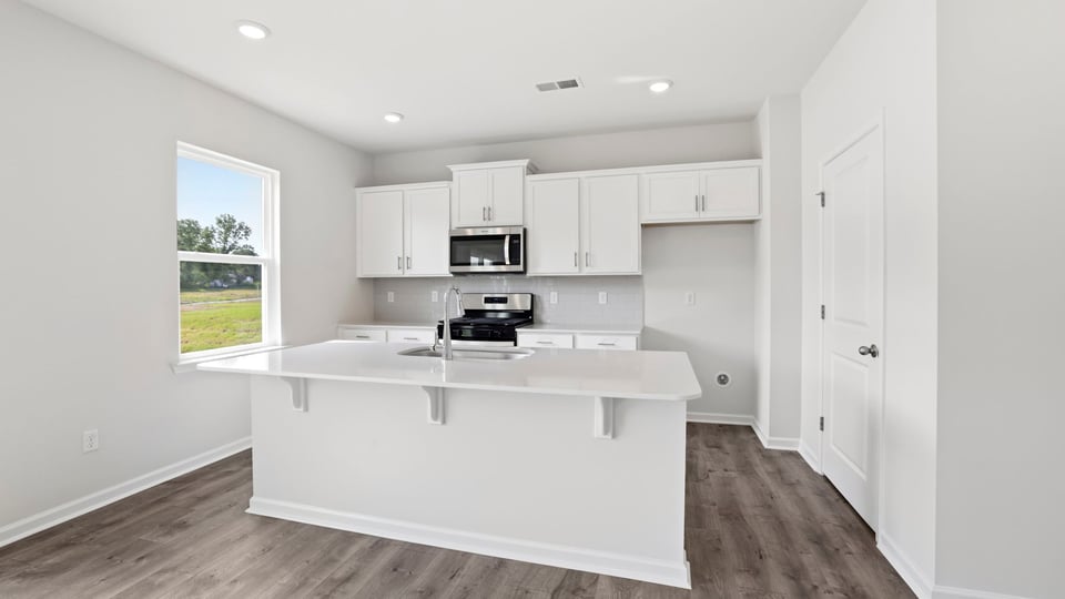 Kitchen and island with quartz countertops.
