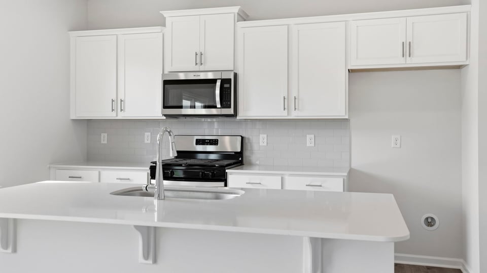 Kitchen and island with quartz countertops.