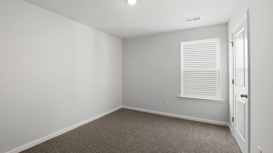 Bedroom with carpet and window.