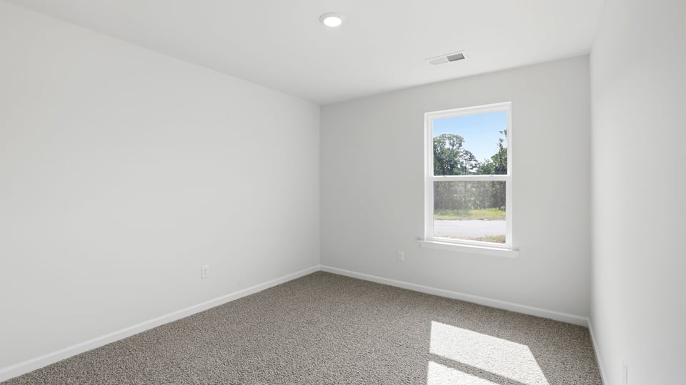 Bedroom with carpet and window.