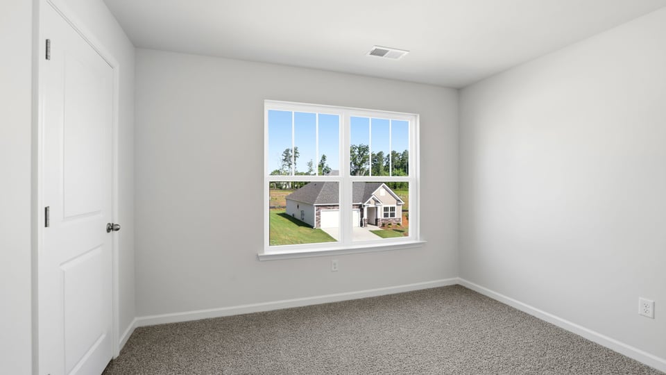 Bedroom with carpet and window.