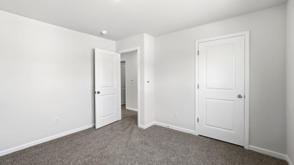 Bedroom with carpet and window.