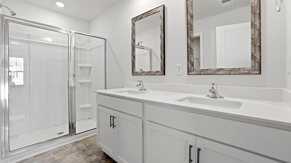 Bathroom with double vanity sink and walk in shower.