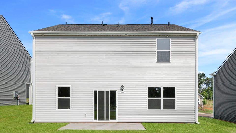 Back exterior of home with large backyard.