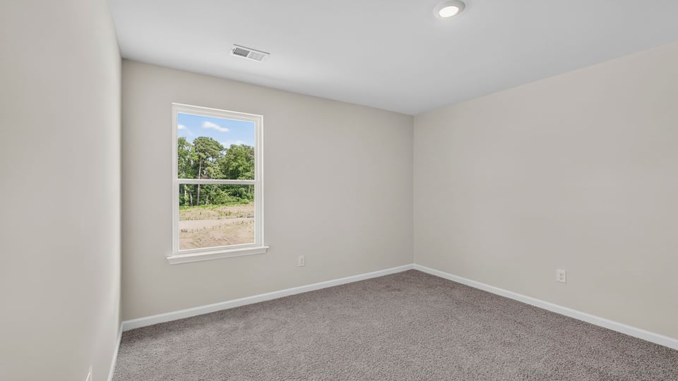 Bedroom with carpet and window.
