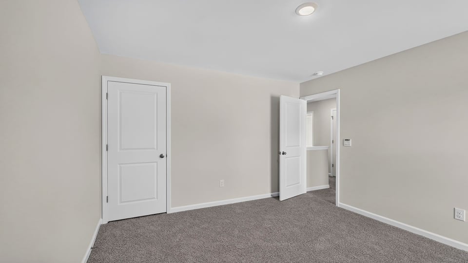 Bedroom with carpet and window.