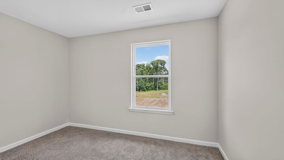 Bedroom with carpet and window.