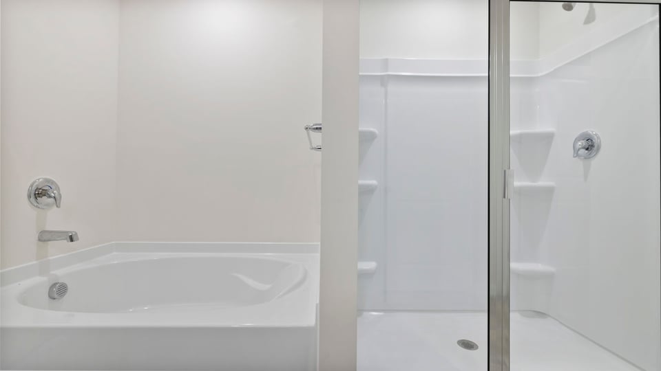 Bathroom with walk in shower and bathtub.
