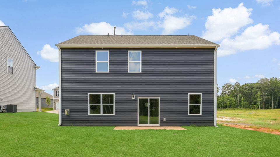 Back exterior of home with large backyard.