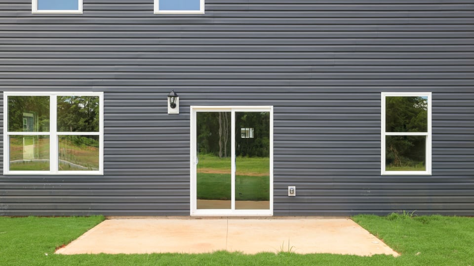 Back exterior of home with small patio.