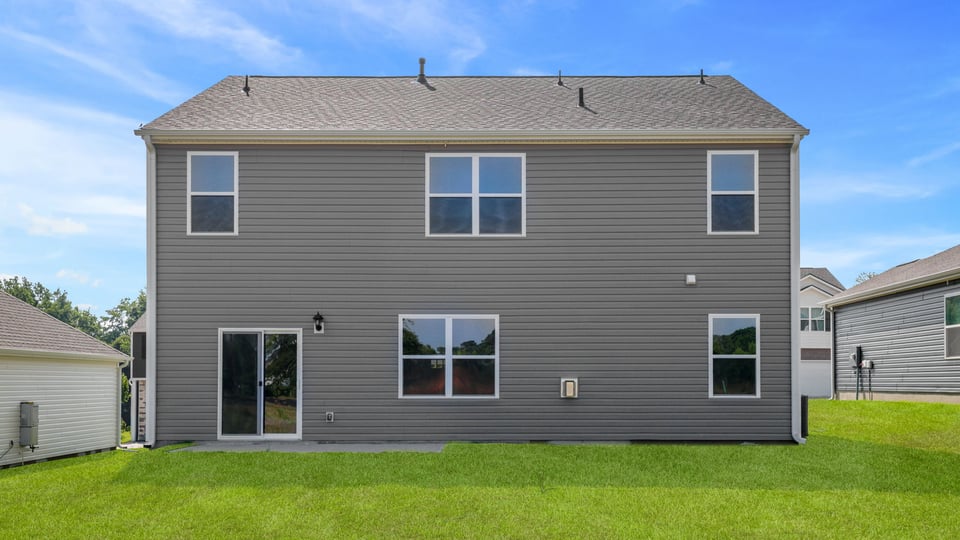 Back exterior of home with large backyard.