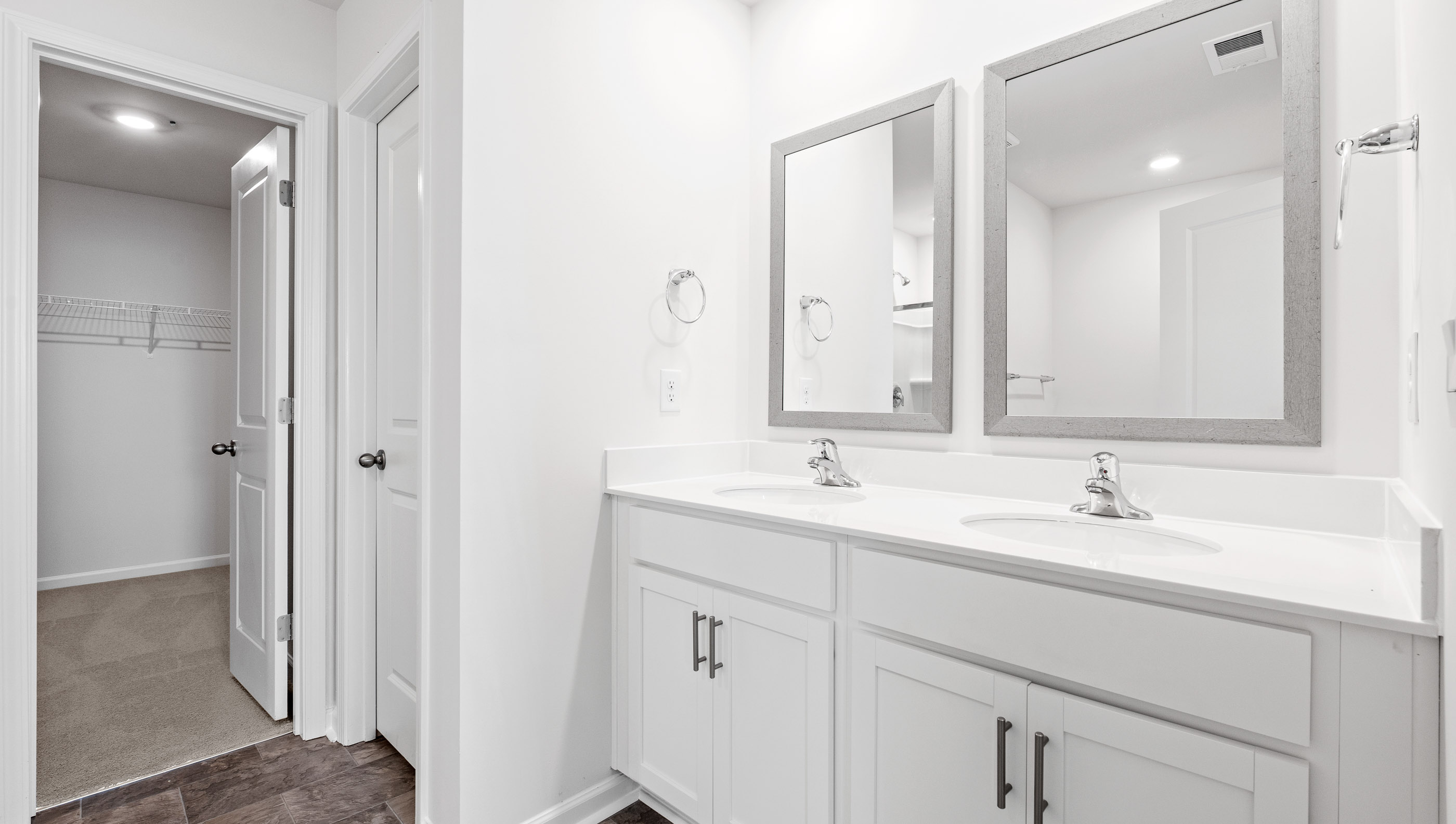 Primary bathroom with dual sink vanity and mirrors.