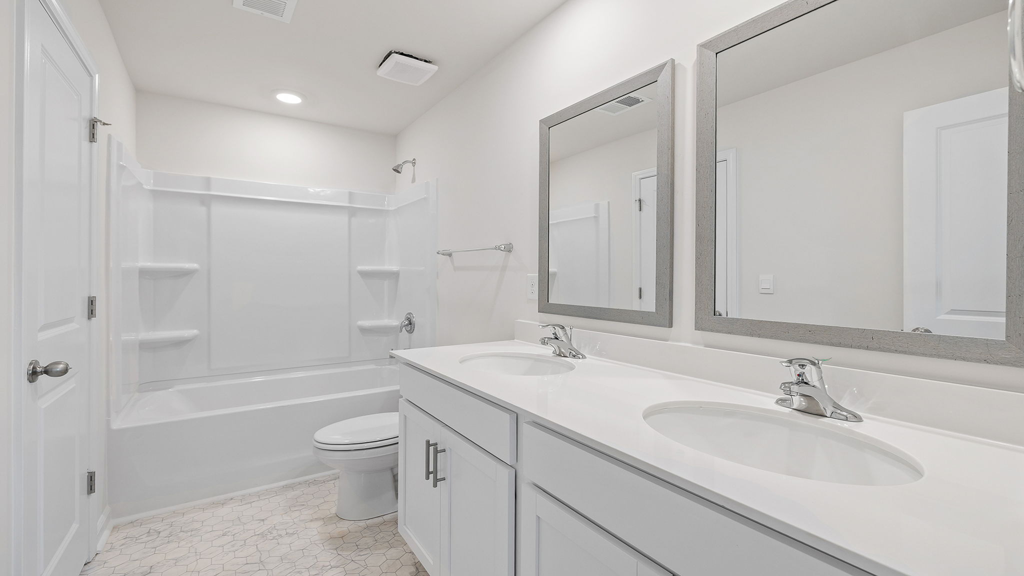 Hall bathroom with dual sink vanity and tub.