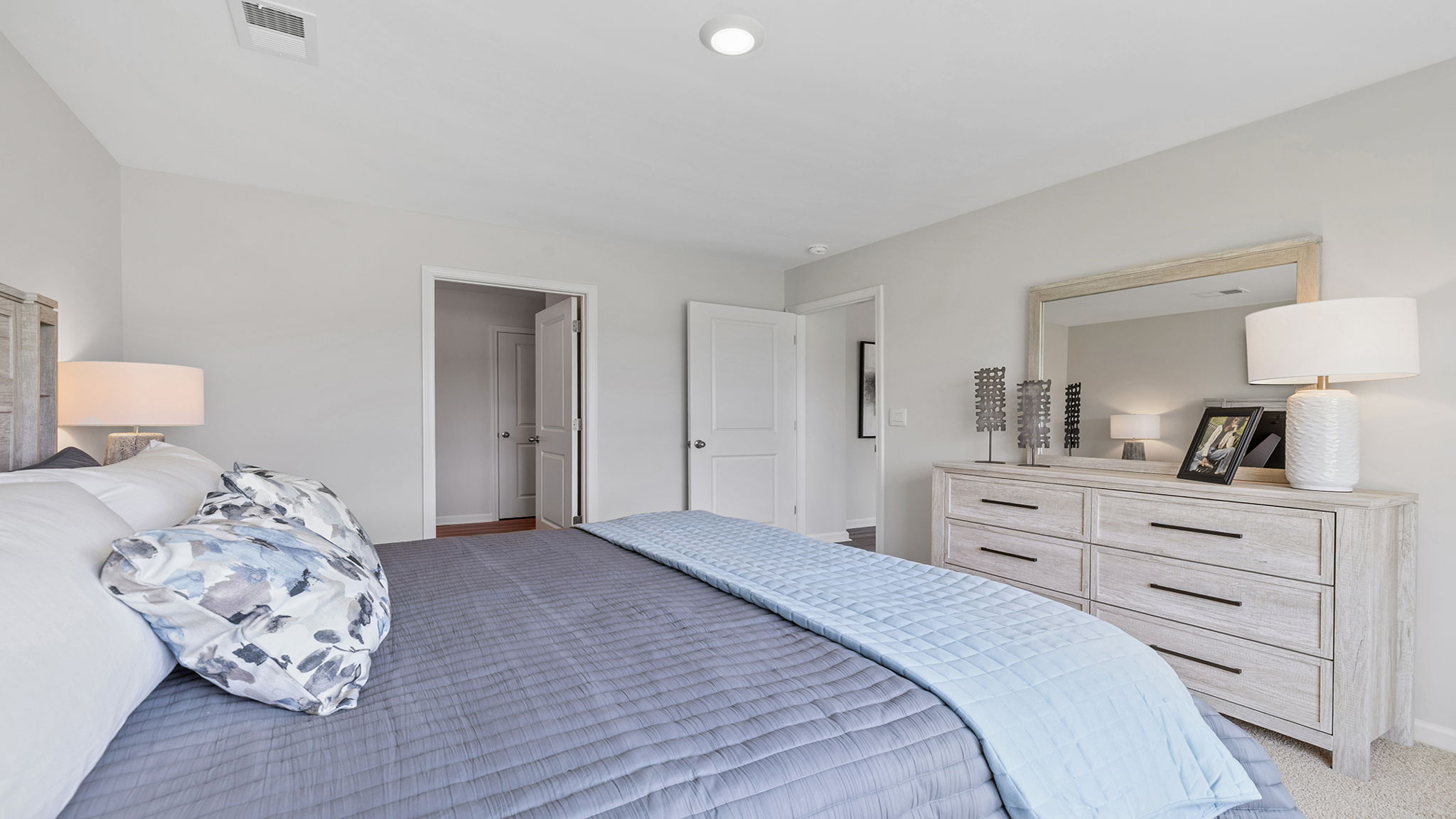 Primary bedroom with windows and carpet.