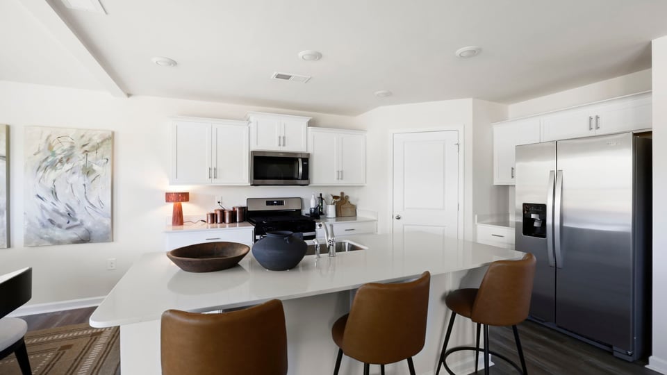 Kitchen and island with quartz countertops and stainless steel appliances.
