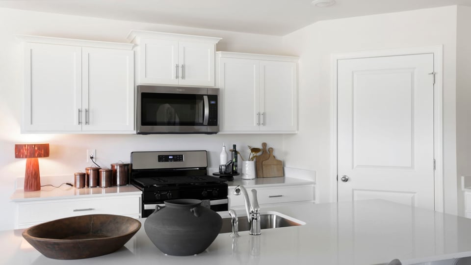 Kitchen and island with quartz countertops and stainless steel appliances.