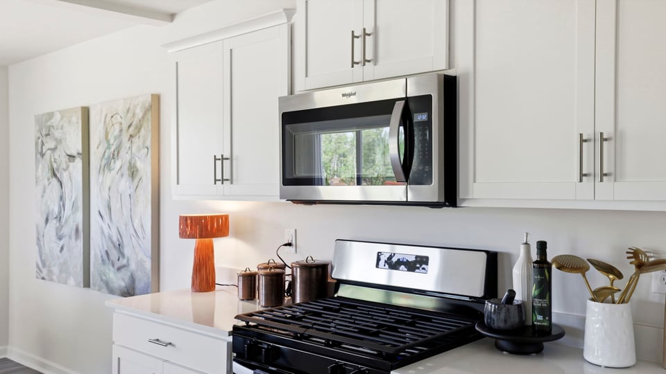 Kitchen and island with quartz countertops and stainless steel appliances.