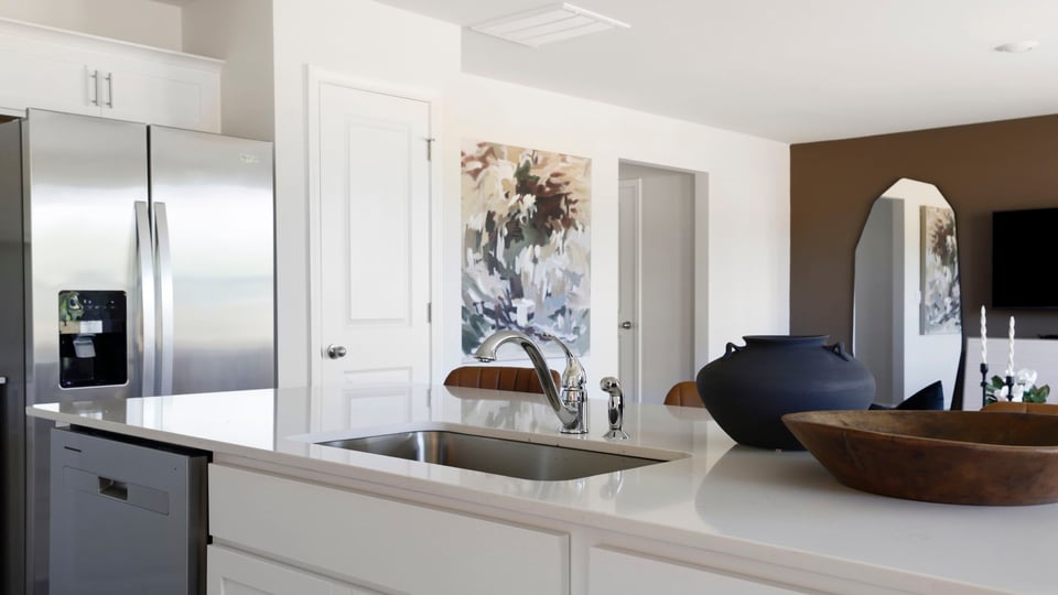 Kitchen and island with quartz countertops and stainless steel appliances.
