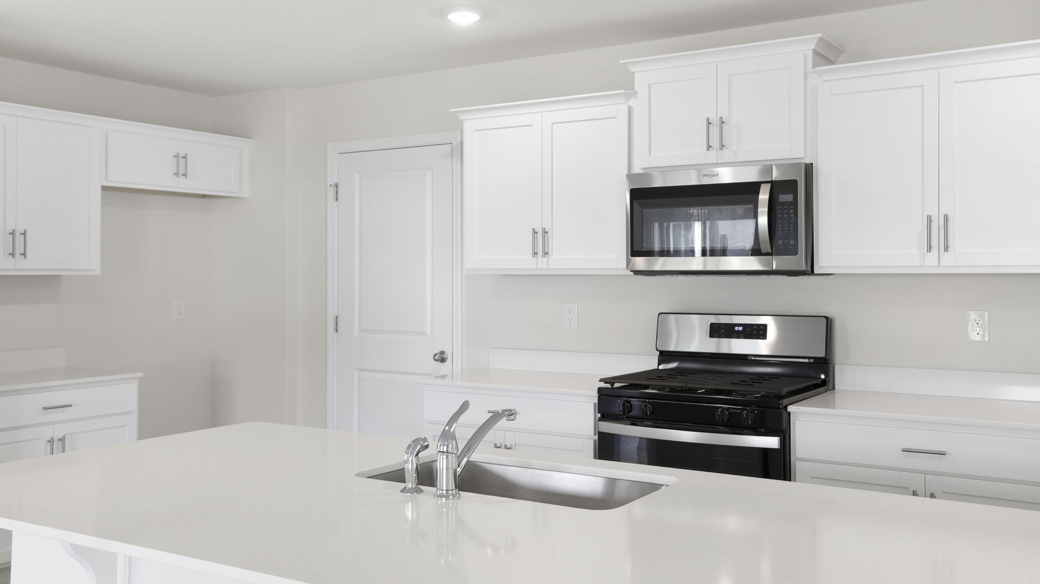 Kitchen with island and quartz countertops.