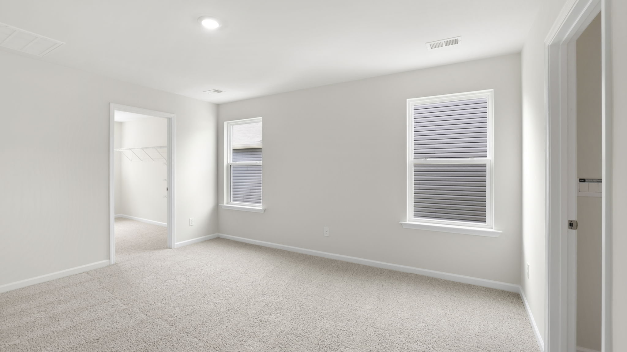 Primary bedroom with window and carpet.